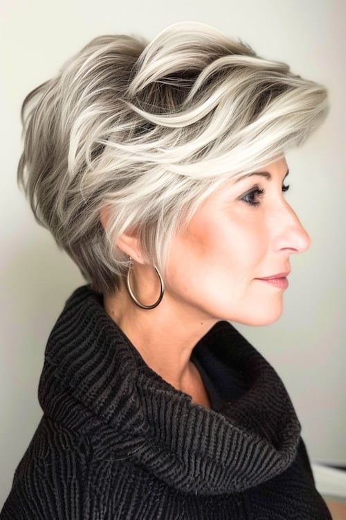 Pixie voluminoso con reflejos platino peinado corto en mujer mayor.