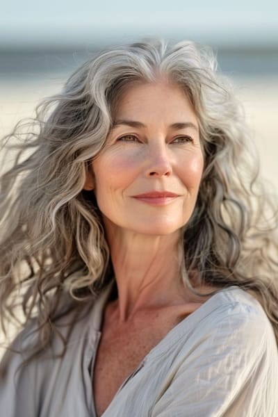 Peinado largo con ondas sal y pimienta para mujeres de más de 70 años.