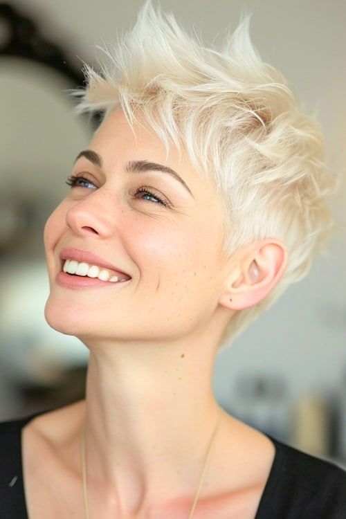 Elegante pixie platino en una mujer sonriente de unos 40 años.