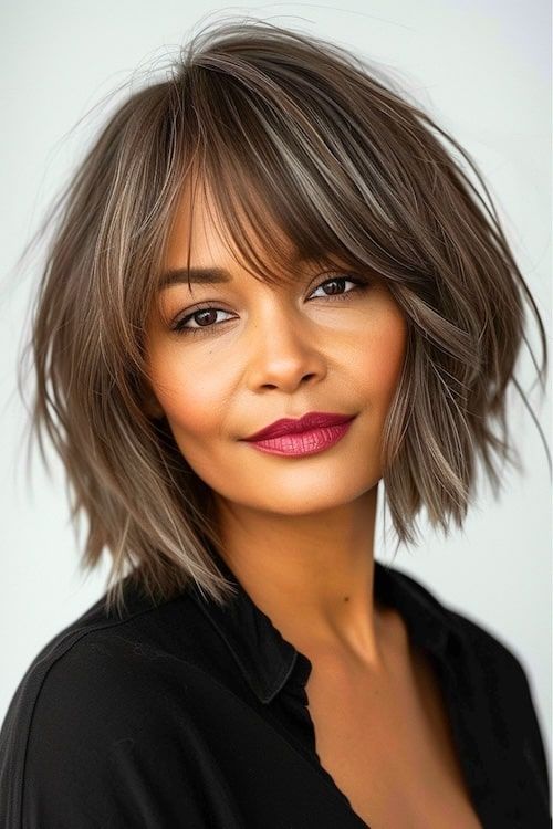 Bob texturizado con flequillo en una bella mujer negra con pintalabios rojo y blusa negra.