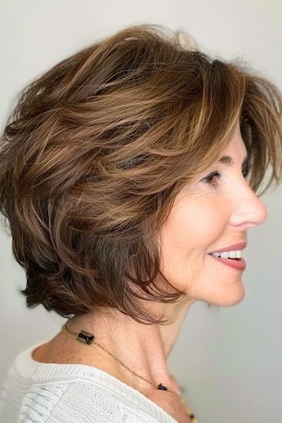 Peinado Bob a capas con plumas para mujeres de más de 50 años con pelo grueso.
