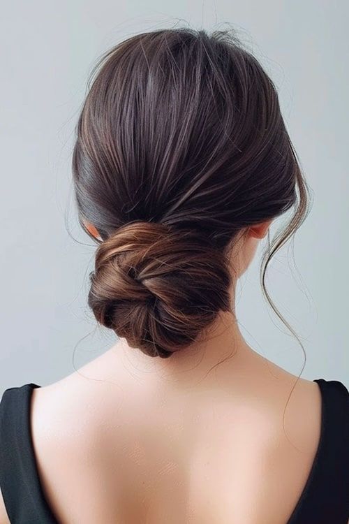 Idea de peinado de graduación minimalista con moño bajo.