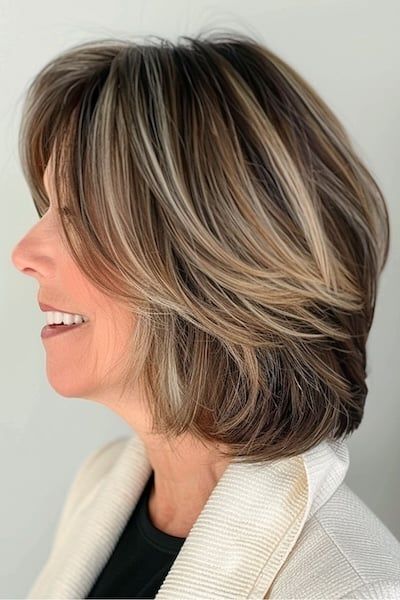 Feathered Layered Lob Peinado para mujeres mayores de 50 años.