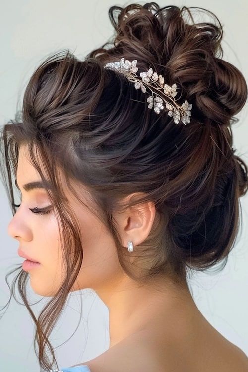 Moño alto despeinado con accesorio floral idea de peinado de graduación.