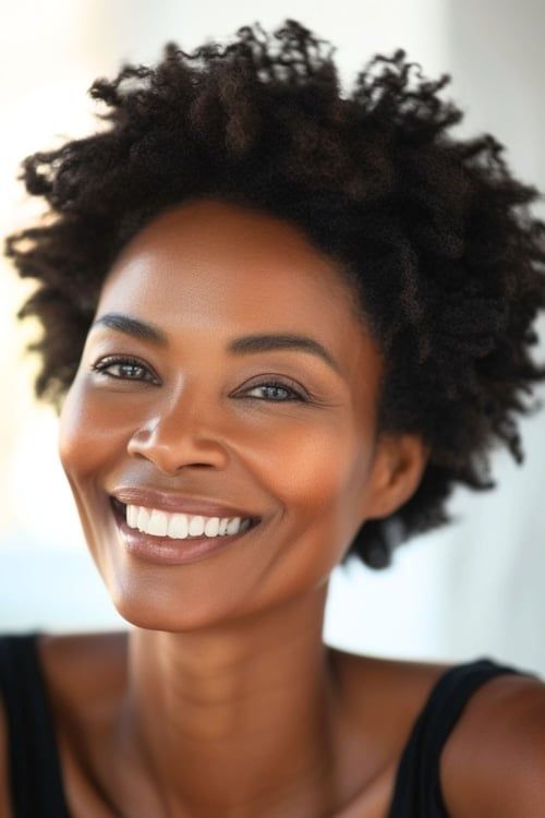 Afro corto con rizos definidos en mujer mayor sonriente.