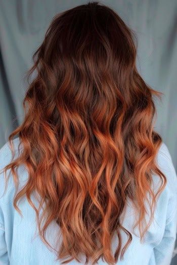 Mechas cobrizas sobre largas ondas castañas.