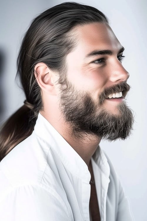 Cola de caballo baja polaca con barba en hombre atractivo, vista lateral.