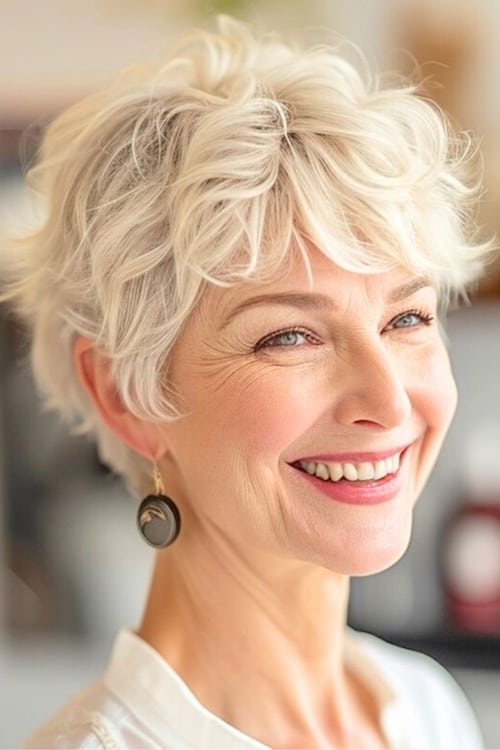 Peinado pixie corto rubio ondulado en mujer sonriente de más de 60 años.